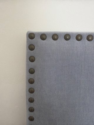 Cabecero de tela gris con tachuelas