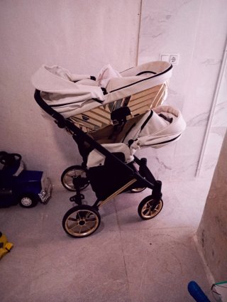 Carro de bebé blanco y dorado