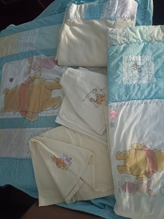 Conjunto Edredón Winnie The Pooh y su ropa cuna.