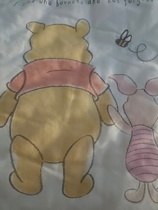 Conjunto Edredón Winnie The Pooh y su ropa cuna.