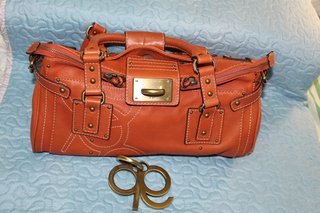 Bolso naranja de piel con detalles metálicos