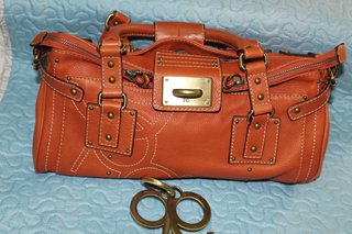 Bolso naranja de piel con detalles metálicos