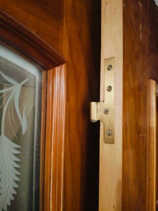 Dos puertas de madera y una con cristal decorado.