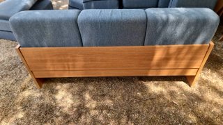Sofá de tela azul con estructura de madera,