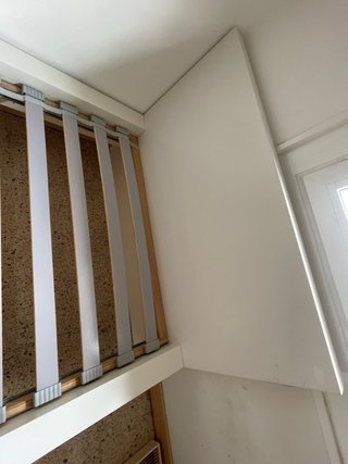 Cama individual blanca con cabecero