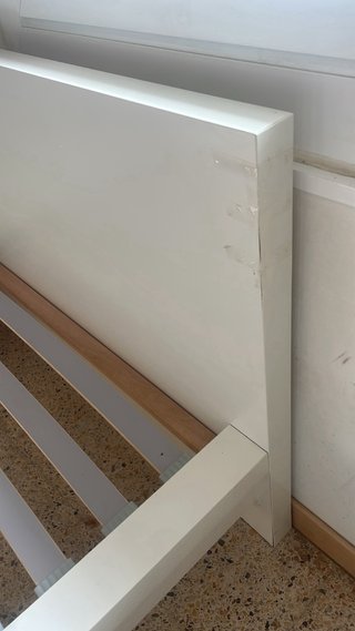 Cama individual blanca con cabecero