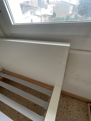 Cama individual blanca con cabecero