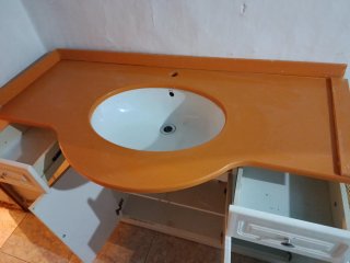 Mueble de baño con lavabo naranja y blanco