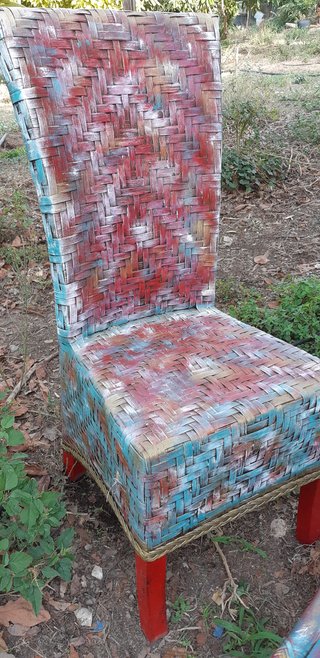 Sillón de mimbre con reposapiés.