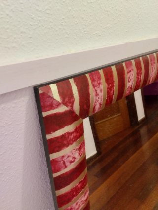 Espejo decorativo con detalles plateados.