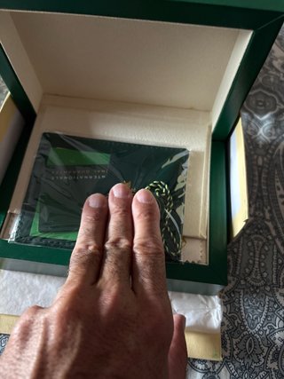 Caja de reloj de lujo con papeles y tarjeta