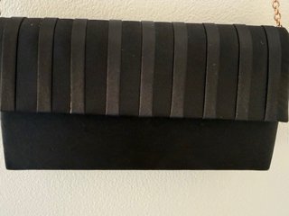 Pochette nera con catena dorata.