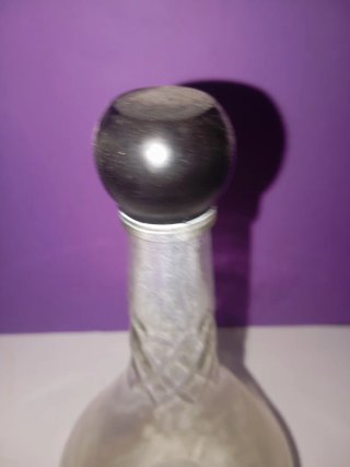 Botella antigua de vidrio con tapón negro