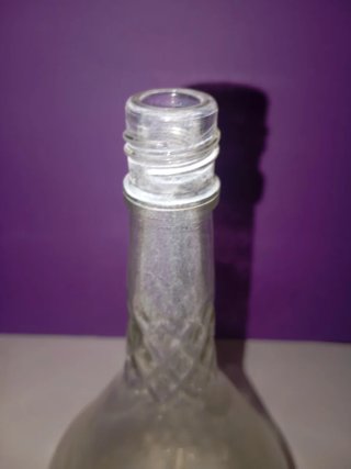 Botella antigua de vidrio con tapón negro