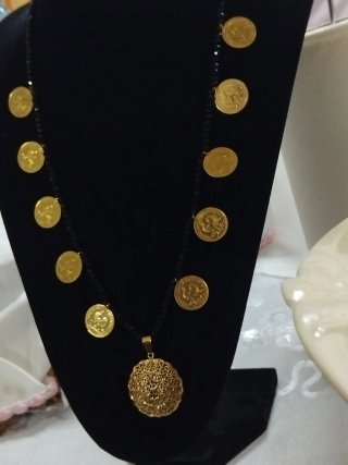 Collar de cuentas negras con monedas doradas