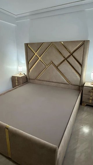 Cama tapizada beige y dorada