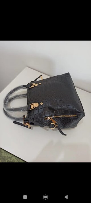 Bolso de mano negro con detalles dorados