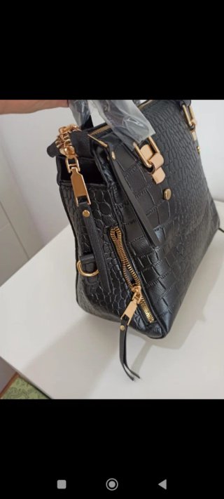Bolso de mano negro con detalles dorados