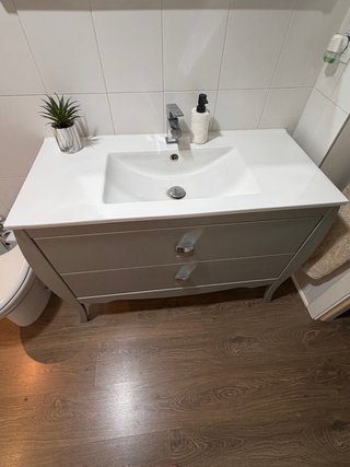 Mueble de baño gris con lavabo y espejo