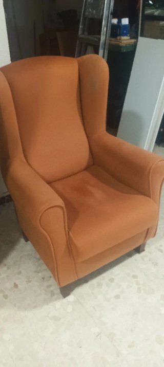 Butaca orejera naranja de tela anti manchas.