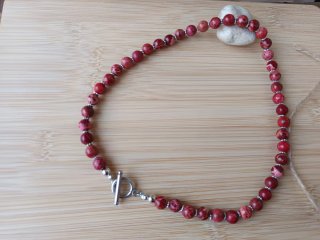 Collar elegante de piedras rojas y cierre plateado