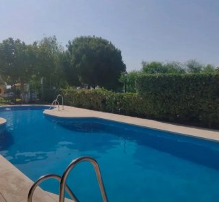 Piscina con tobogán y tumbonas