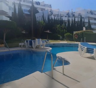 Piscina con tobogán y tumbonas