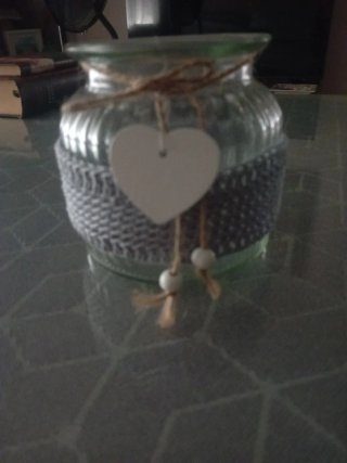 Jarrón de cristal con tejido gris y corazón