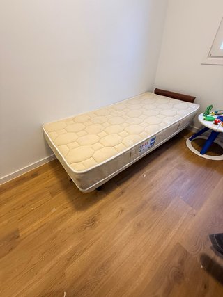 Cama con base tapizada y patas