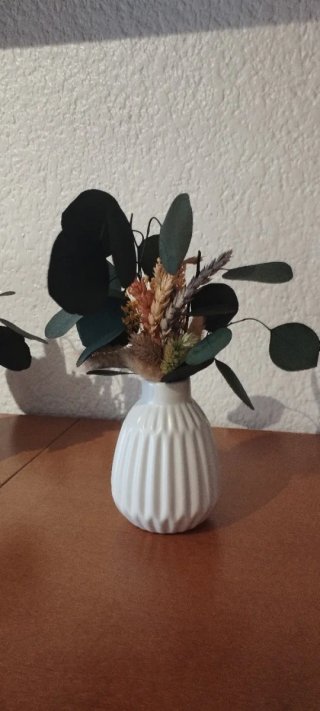 Jarrón blanco con flores secas naturales.