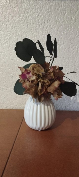 Jarrón blanco con flores secas naturales.