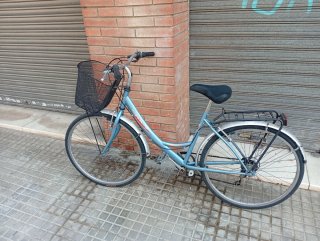 Bicicleta azul con cesta y portabultos.