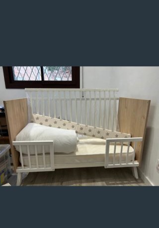 Cuna de bebé con barreras de madera