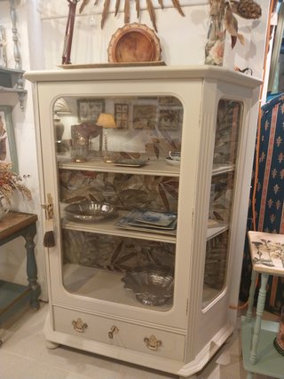 Vitrina de madera beige con detalles dorados