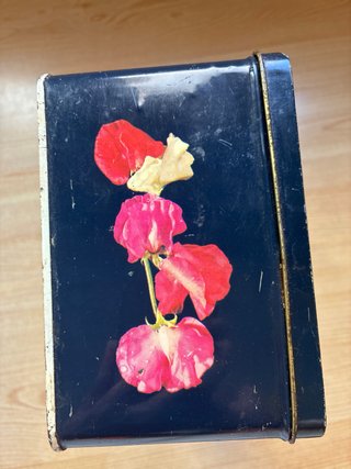 Lata antigua Cola-Cao con dibujo de flores.