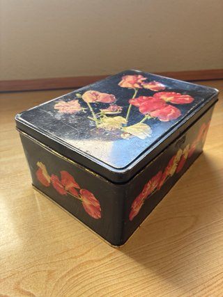 Lata antigua Cola-Cao con dibujo de flores.