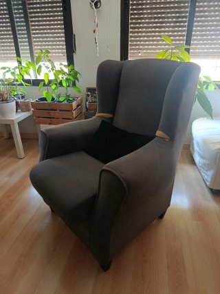 Sillón orejero gris con funda color cereza