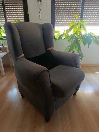 Sillón orejero gris con funda color cereza