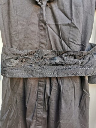 Vestido negro con volantes y cinturón y bordados
