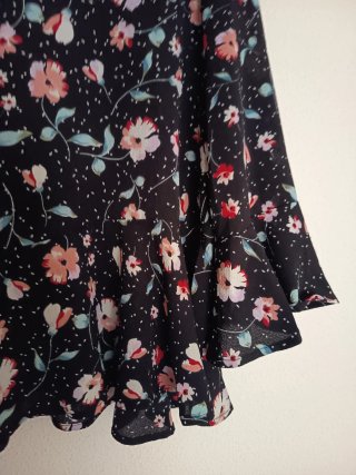 Blusa negra con estampado floral y volantes