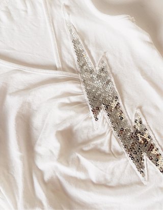 Top bianco smanicato con fulmine paillettes
