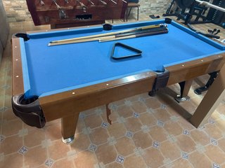 Mesa de billar con tacos y triángulo
