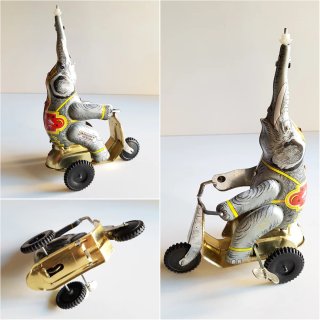 Elefante de metal hojalata en triciclo