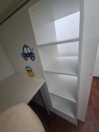 Cama alta blanca con estanterías y escalera