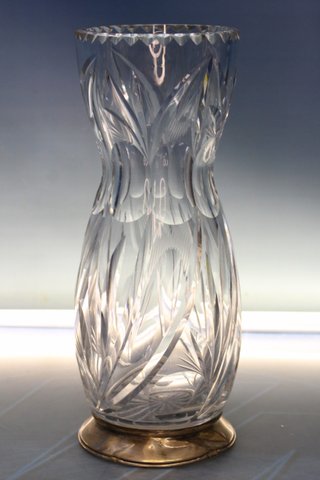 Jarrón de cristal tallado y base de plata con contrastes.
