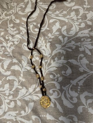Collar marrón con colgante espiral dorado