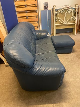 Sofá de piel azul con otomana