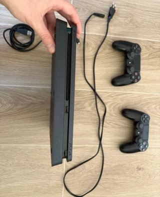 PS4 (PlayStation 4) Nera con un Controller