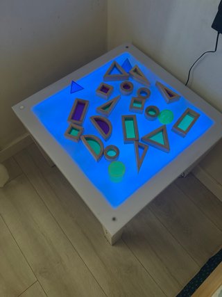Mesa de luz con mando y figuras traslucidas