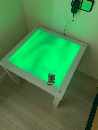 Mesa de luz con mando y figuras traslucidas